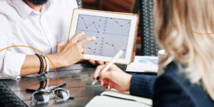 A businessman zooms into graphs on his tablet during a meeting